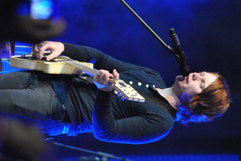 the young woman with long hair playing a guitar