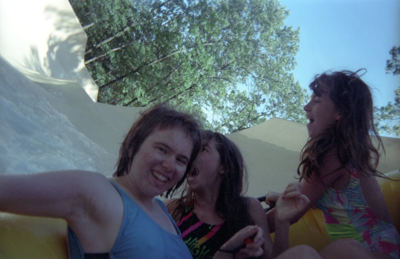 three young women taking pictures at a fair