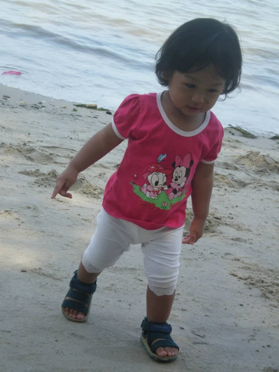 a small child on the beach with sand