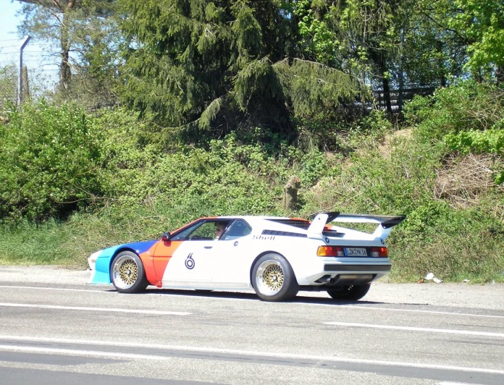 a colorful car sits on the side of the road