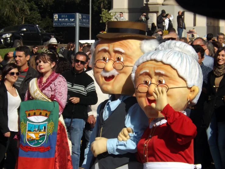 a group of people wearing big masks in front of a crowd