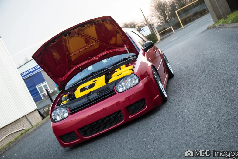 a red car with yellow details and a hood