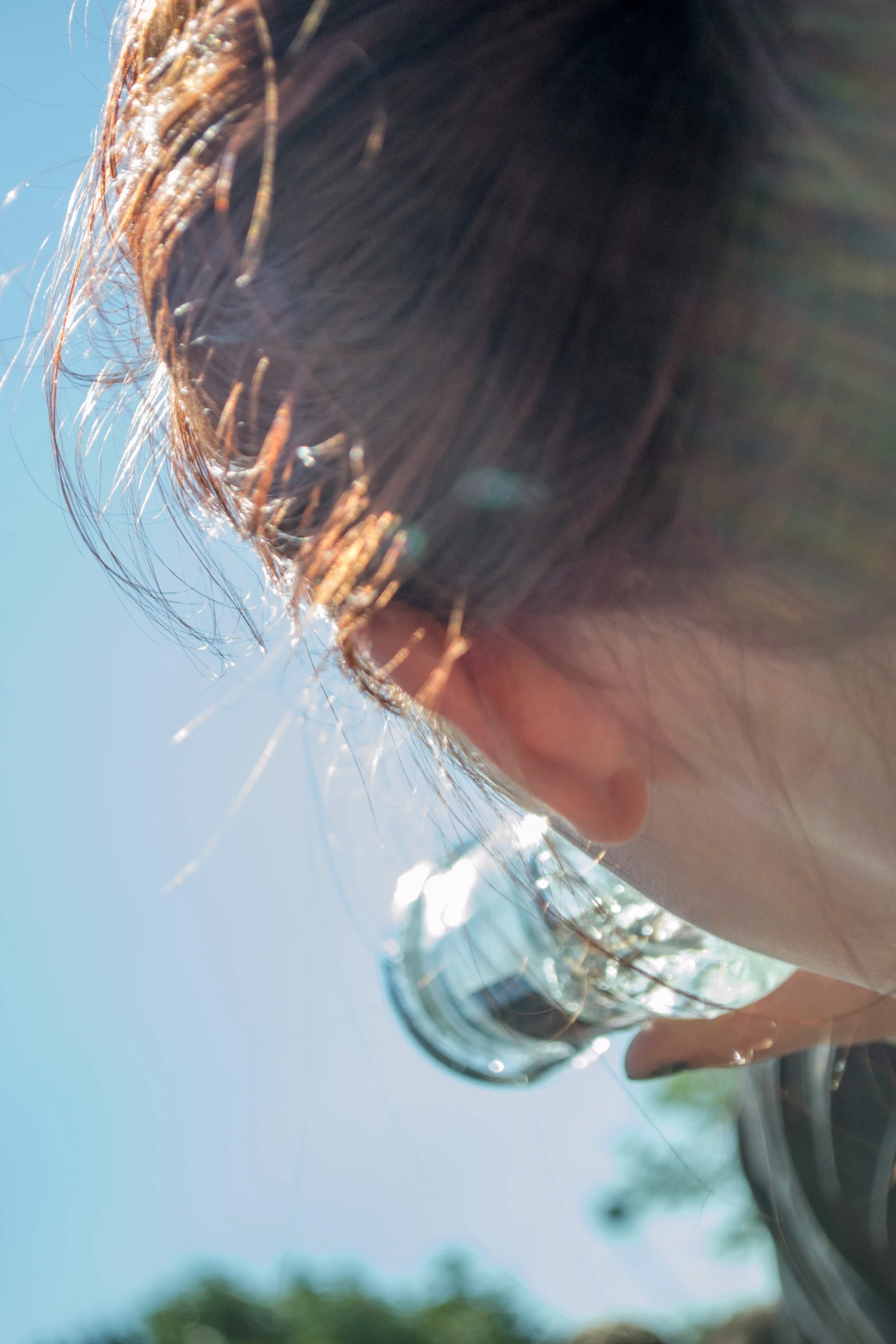 an asian woman is smelling the water in her glass