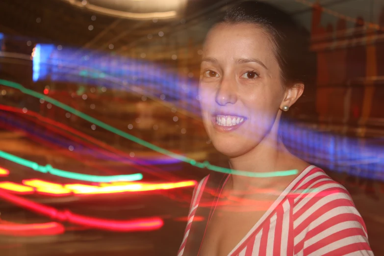 a woman standing in front of the camera with a blurry background