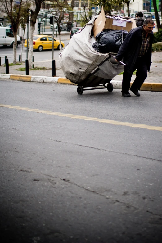 a man pulling a big piece of luggage through the street