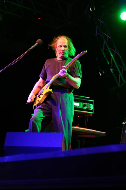 a man is playing a guitar and singing into the microphone