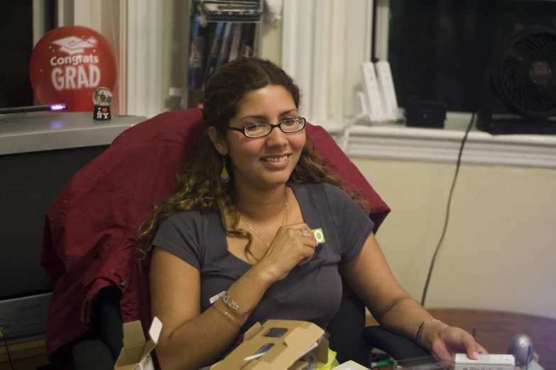 a woman sits in a chair with gifts in front of her