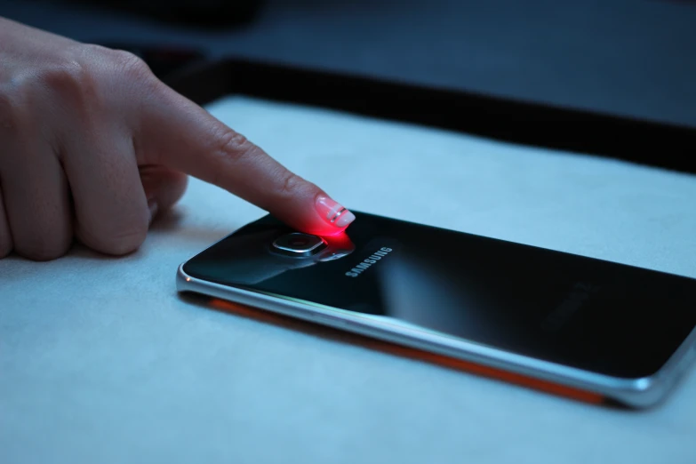 a hand is touching an illuminated samsung phone