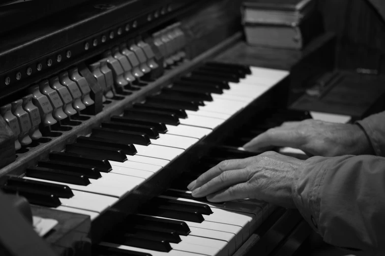 a close up of two hands playing on a piano