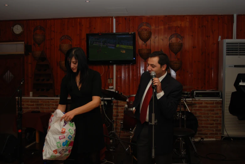 a woman in black is next to a man wearing a suit and a red tie