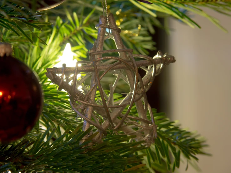 the star ornament hangs on a christmas tree