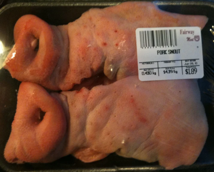 two large raw chicken pieces sitting on top of a baking pan