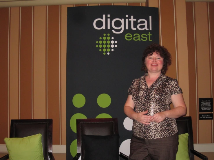 a woman standing in front of a digital east sign