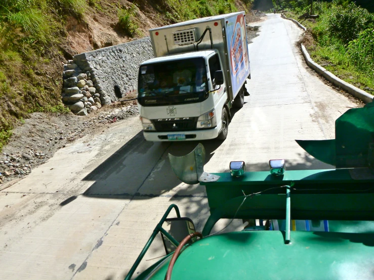 a van driving along a mountain road on the side of a hill