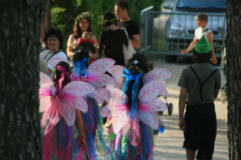 people are gathered around dressed up in colorful fairy costumes