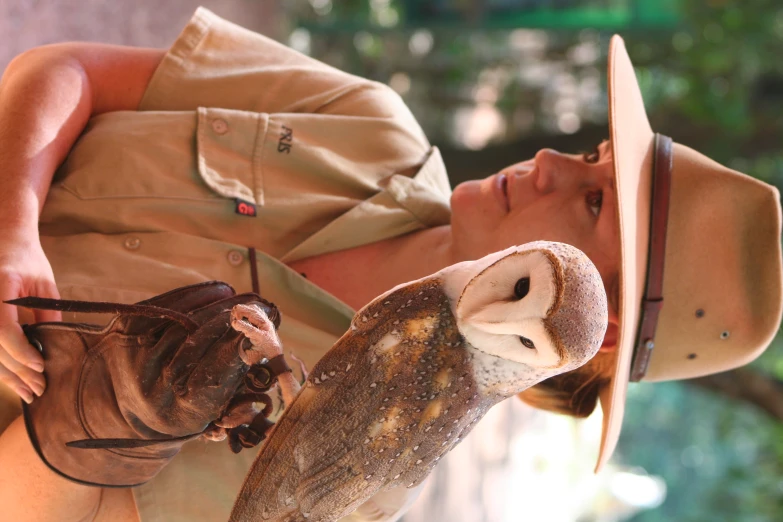 a woman holding an owl on a glove