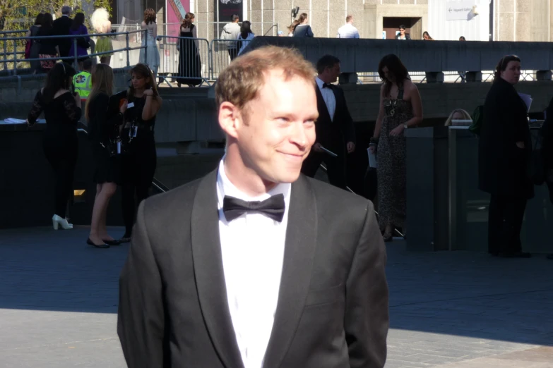 a man wearing a black suit and bow tie