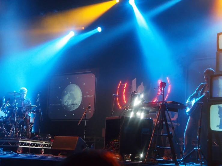 band performing on stage with colorful lighting in background