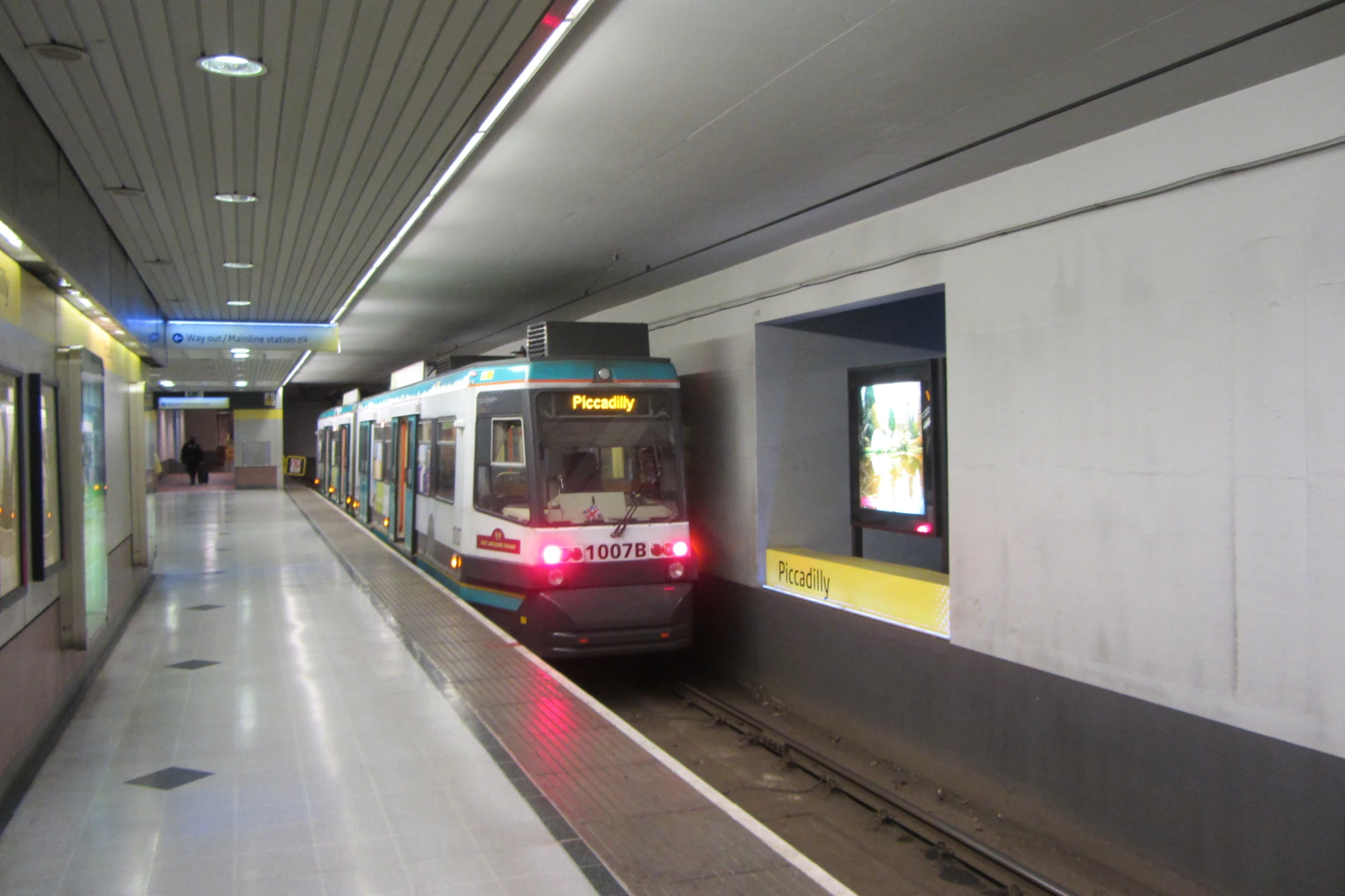 a train pulling into a station with it's light on