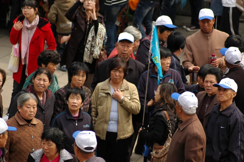 several people with hats walking on a city street