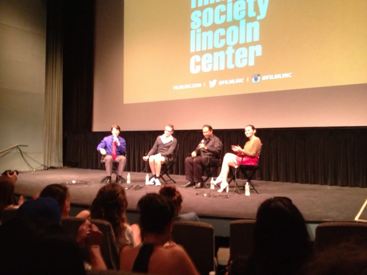 three people on stage talking at a convention