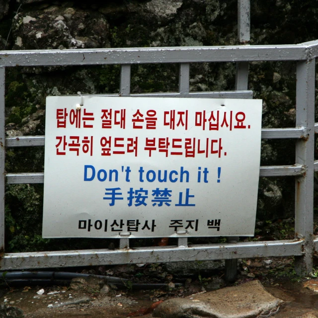 a sign that is on the ground near some rocks