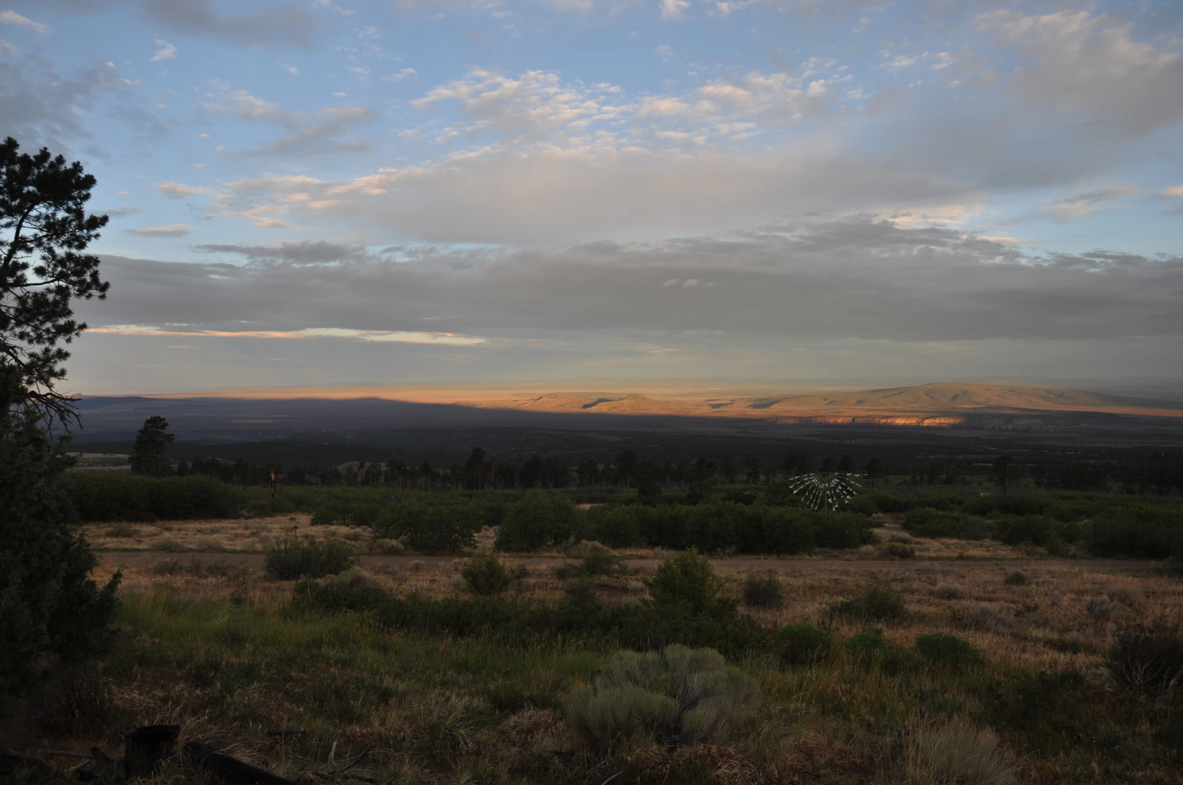 a field is shown during the day with mountains in the background