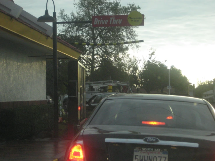 some cars sitting in the road at a stop sign