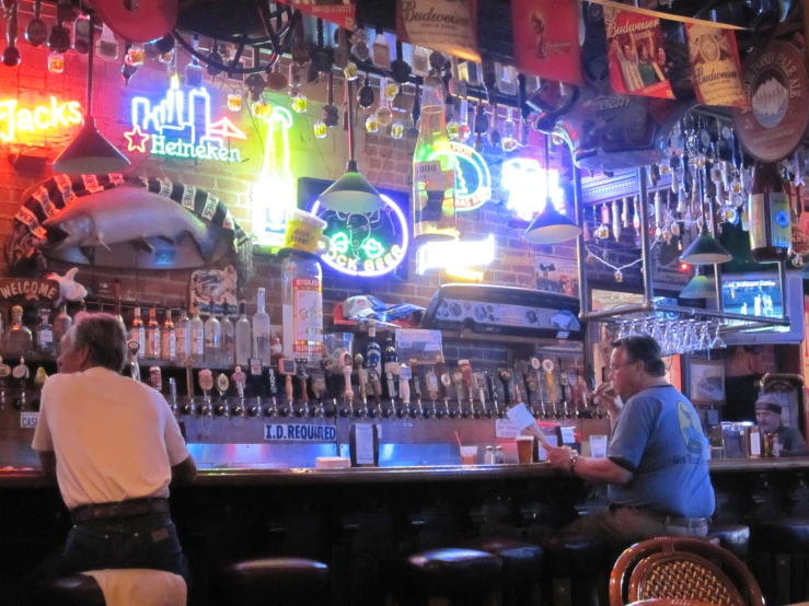 two men are standing in front of a bar