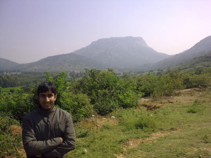 a man standing on top of a grass covered field