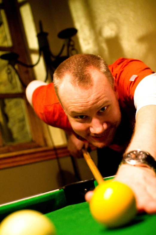 a man leaning over the edge of a pool table