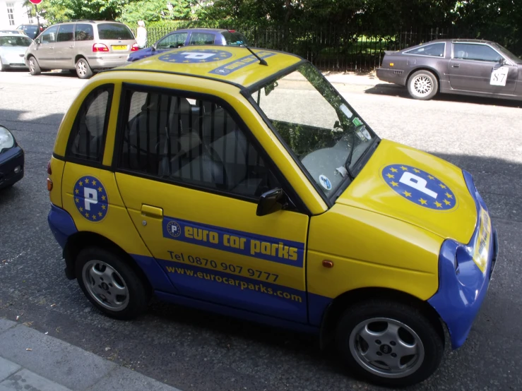 the small yellow car is painted in various colors