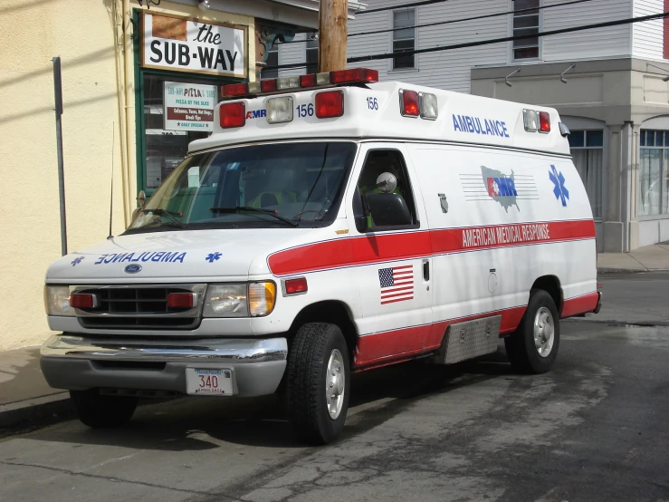 an ambulance is parked at a curbside on the sidewalk
