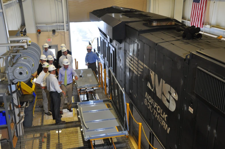 several workers are standing around a coal train