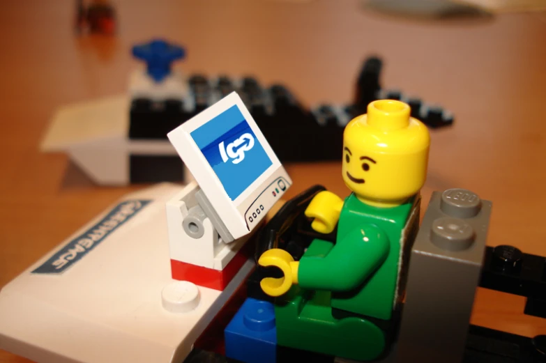 a lego man with a white sign in his hand