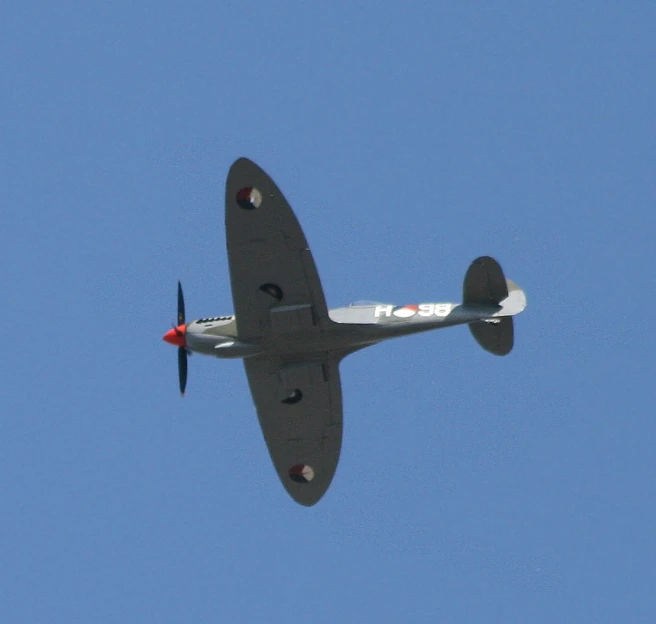 a small airplane flying in a bright blue sky