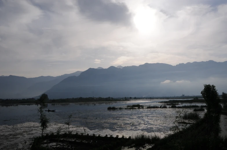 a lake and mountain range with clouds and water