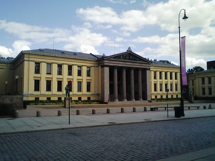 an old building with pillars in the front and a flag on top