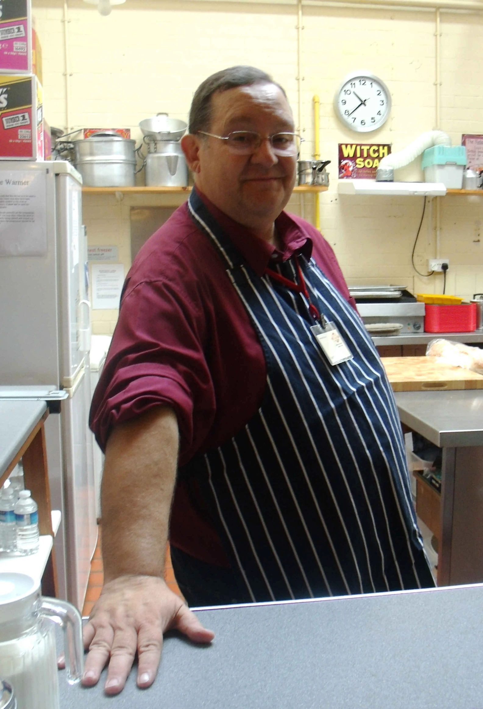 a man in an apron stands at the counter