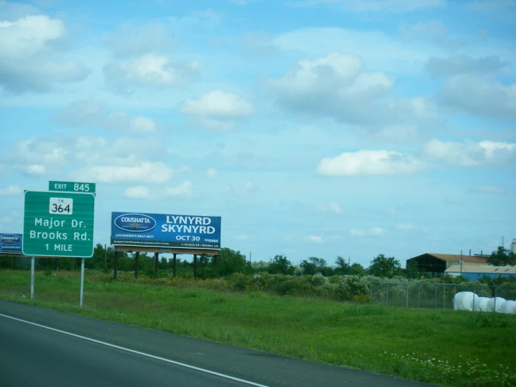 several green street signs on an urban highway