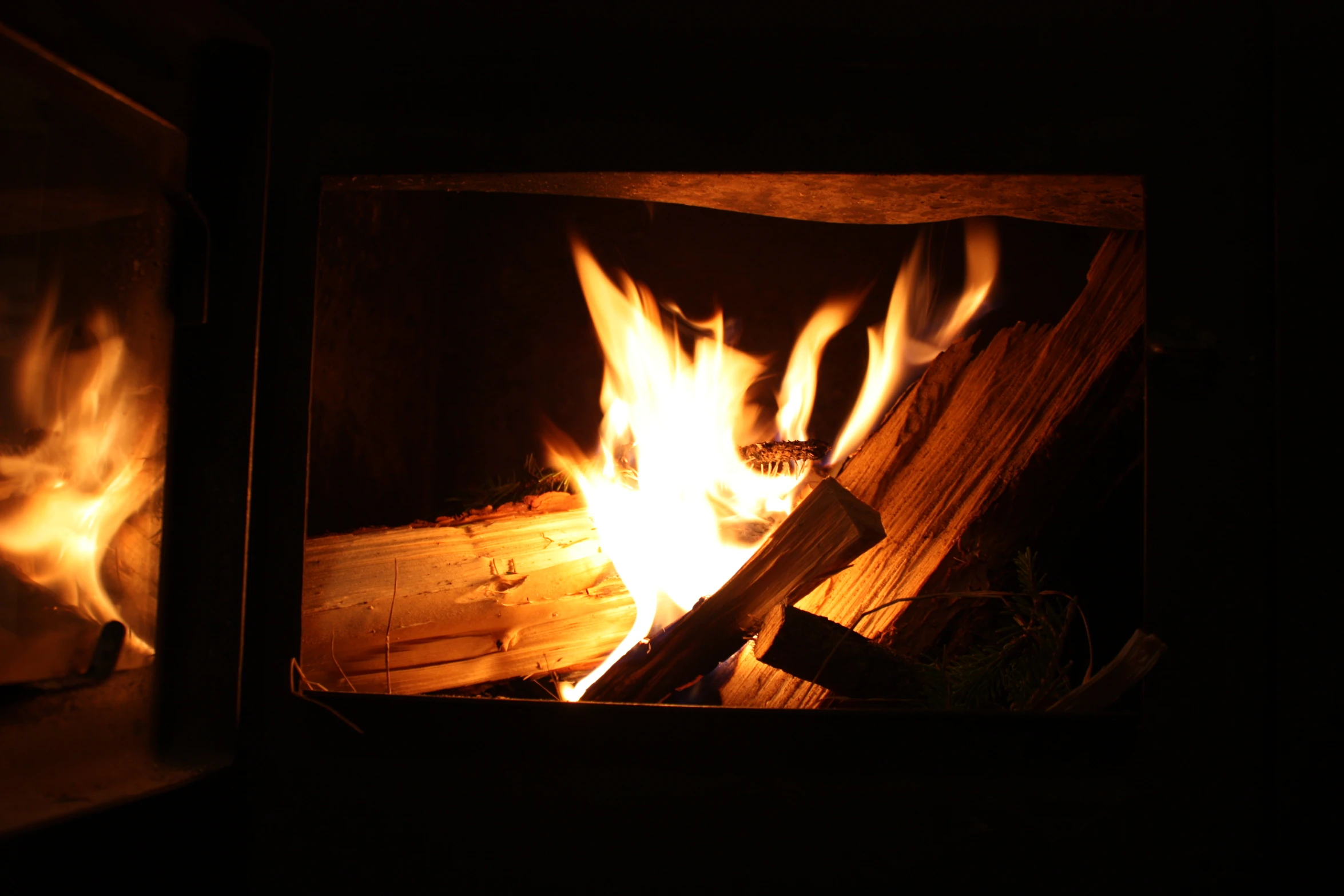 fire flames in a wood fired stove in a dark room