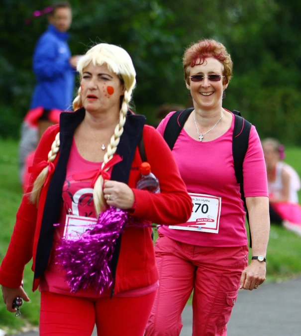 two ladies with clown noses walking down a path