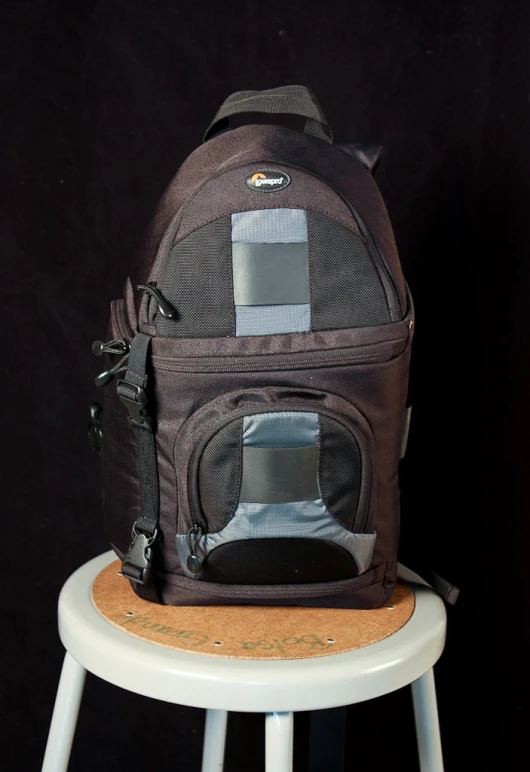 an animal carrier sits on a stool next to a black background