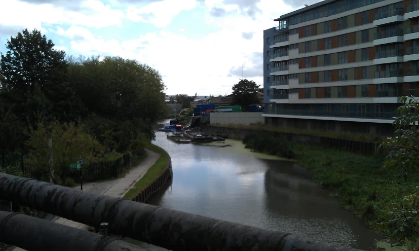 a river running past some buildings and trees