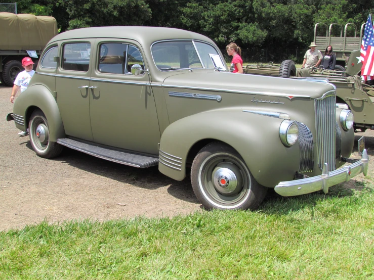 old fashion military truck sitting on display at an antique car show