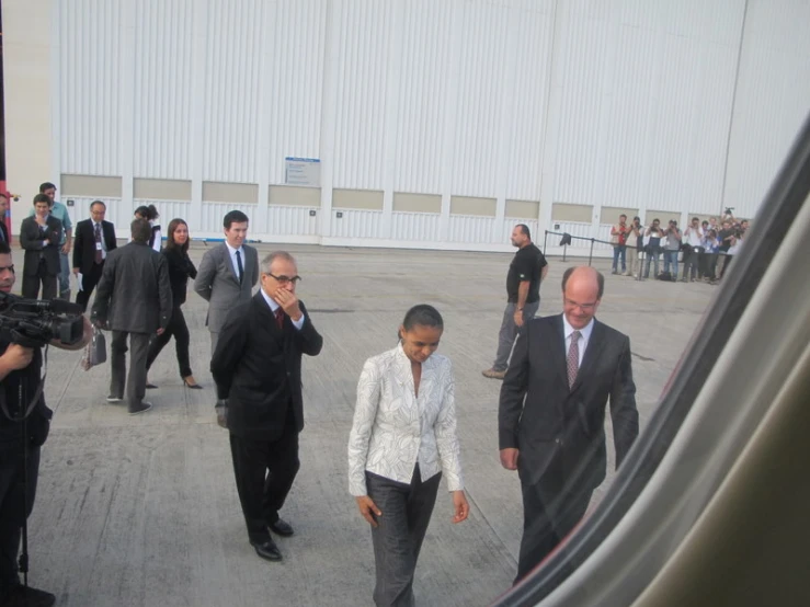 a group of people in business attire walking towards an airplane