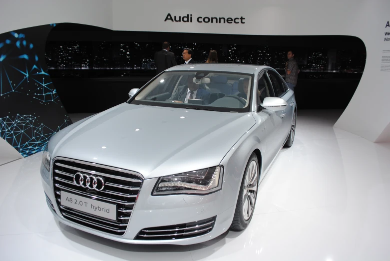 a shiny white audi car with people around it