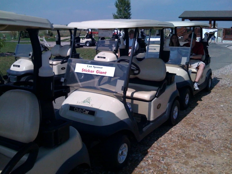 people in golf carts parked in the dirt