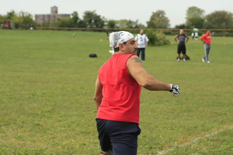 a man on a field holds a glove out while playing frisbee