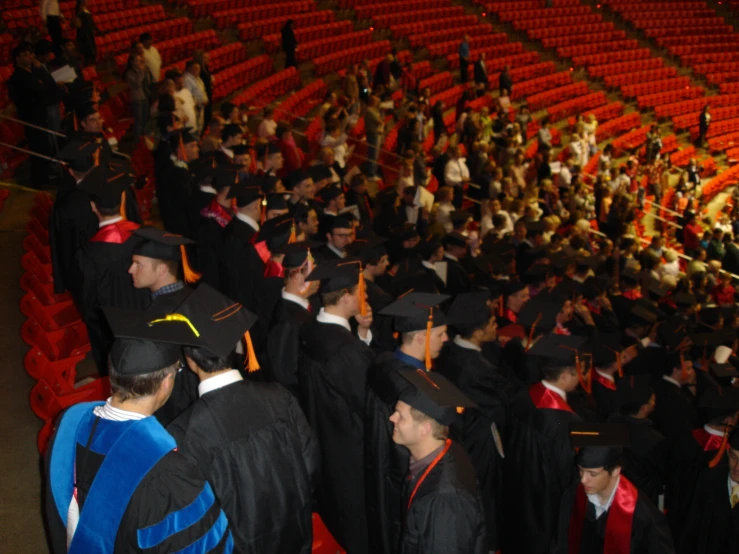 graduates gather in the stadium to receive their degrees